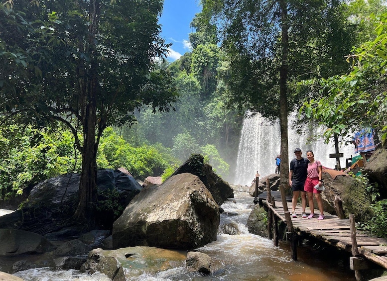 A waterfall, a wooden bridge, and lush greenery. 3