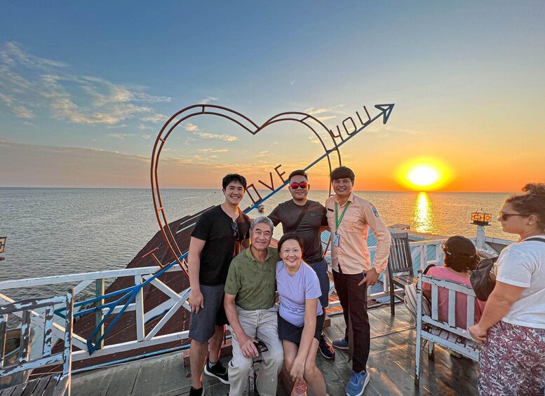 A group of people on a boat with a heart-shaped arrow pointing towards the sun. 2