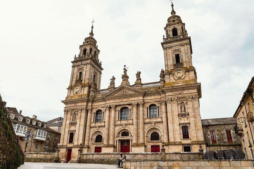 Eine historische Kirche mit zwei Glockentürmen, Rundbogenfenstern und einem markanten Eingang. 3