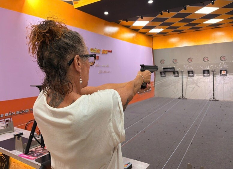 A person aiming a handgun at a shooting range. 2