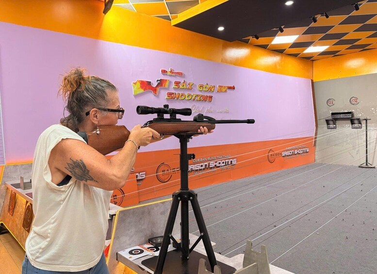 A person aiming a rifle at a shooting range with targets. 3