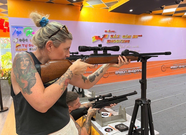 A person aiming a rifle at a shooting range with targets. 4