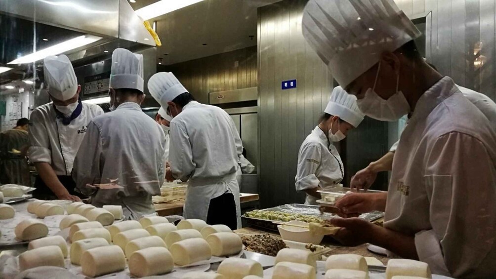 Chefs in a professional kitchen preparing food. 5