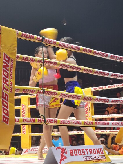 A boxing ring with yellow ropes and 'BOOSTRONG' branding. 3