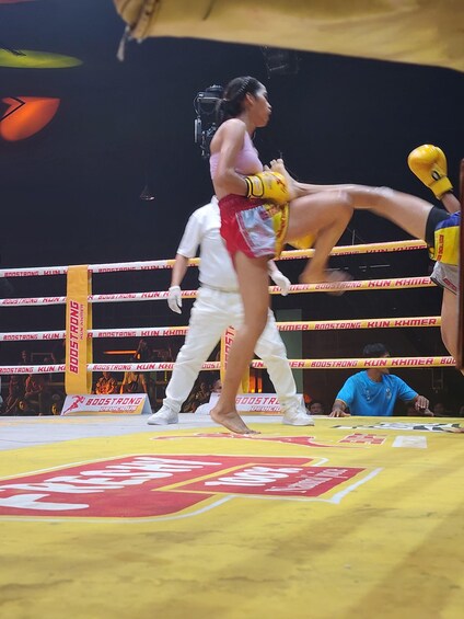 A boxing ring with a person in red shorts and yellow gloves. 4