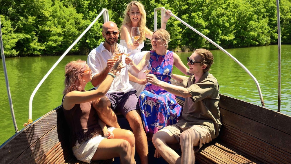 A group of people on a boat with a river and greenery in the background. 2