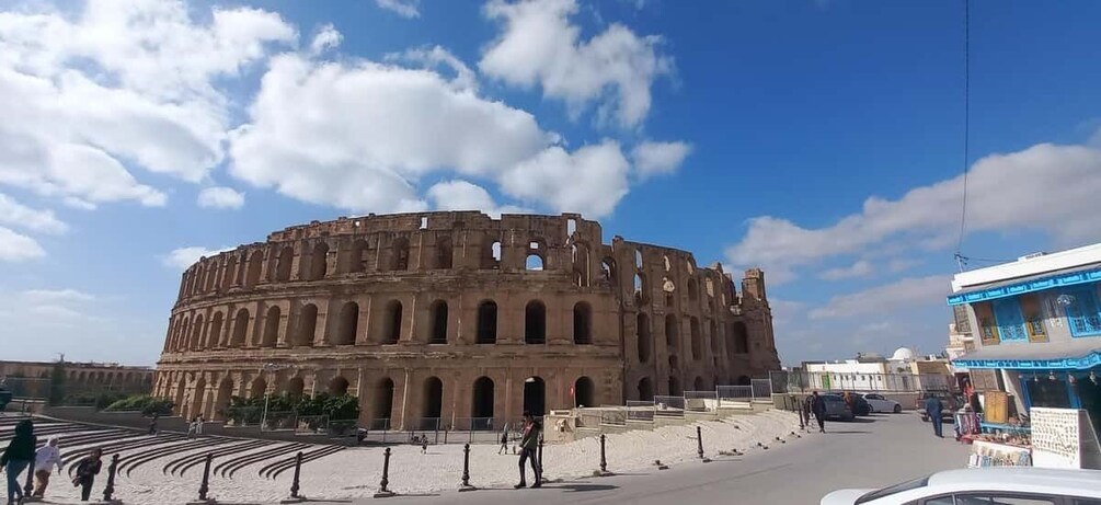 The Colosseum in Rome with a clear sky and a few people walking around. 4