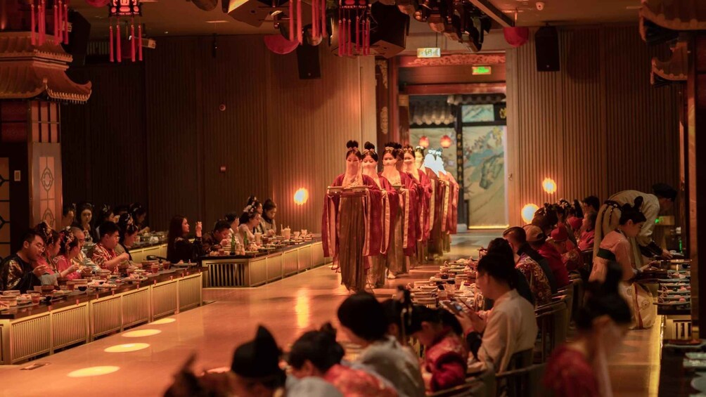 A traditional ceremony with participants in red robes. 1