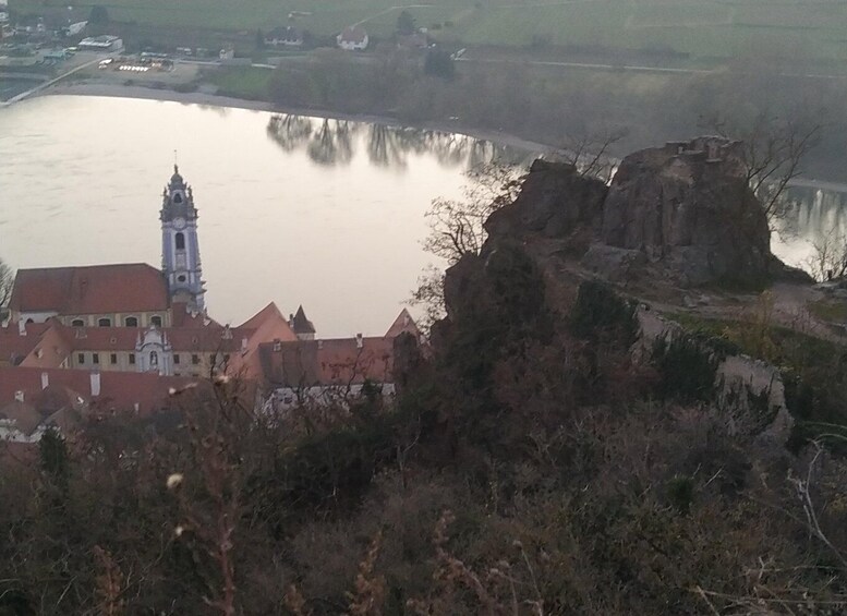 A river, a church with a clock tower, and a rocky outcrop. 3