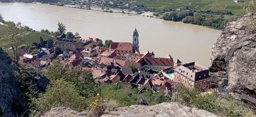 A town with a river, a prominent tower, and surrounding greenery. 4