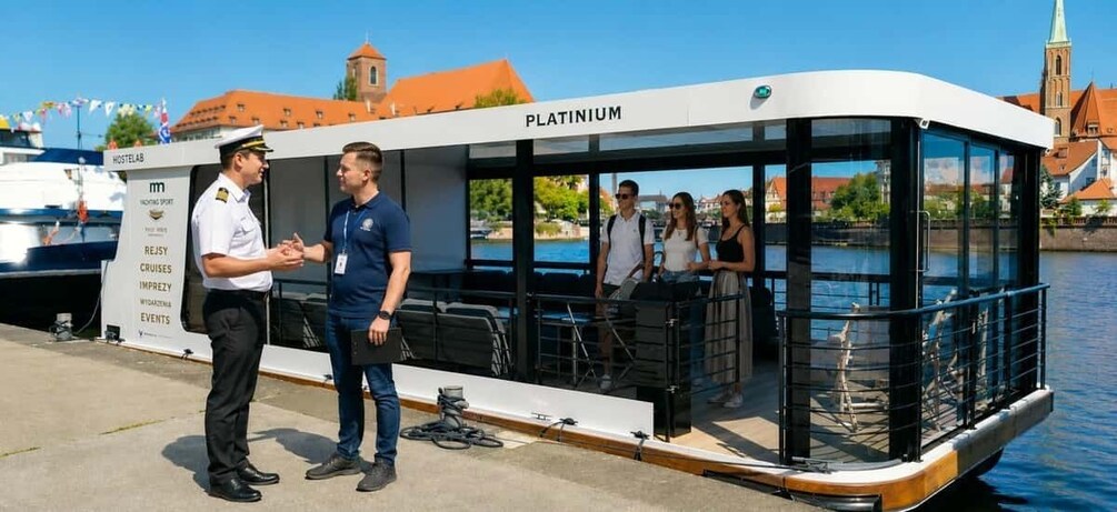 A riverboat named 'Platinum' docked at a port with a cityscape in the background. 1