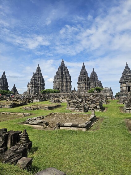 Ancient stone structures with multiple towers, surrounded by grassy areas. 4