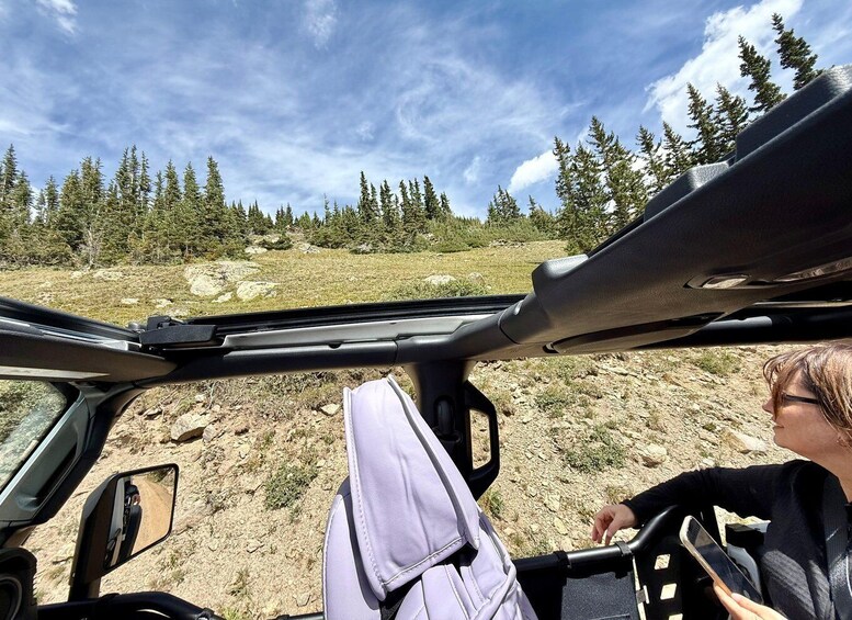 A vehicle interior with a view of a rocky terrain and trees. 3