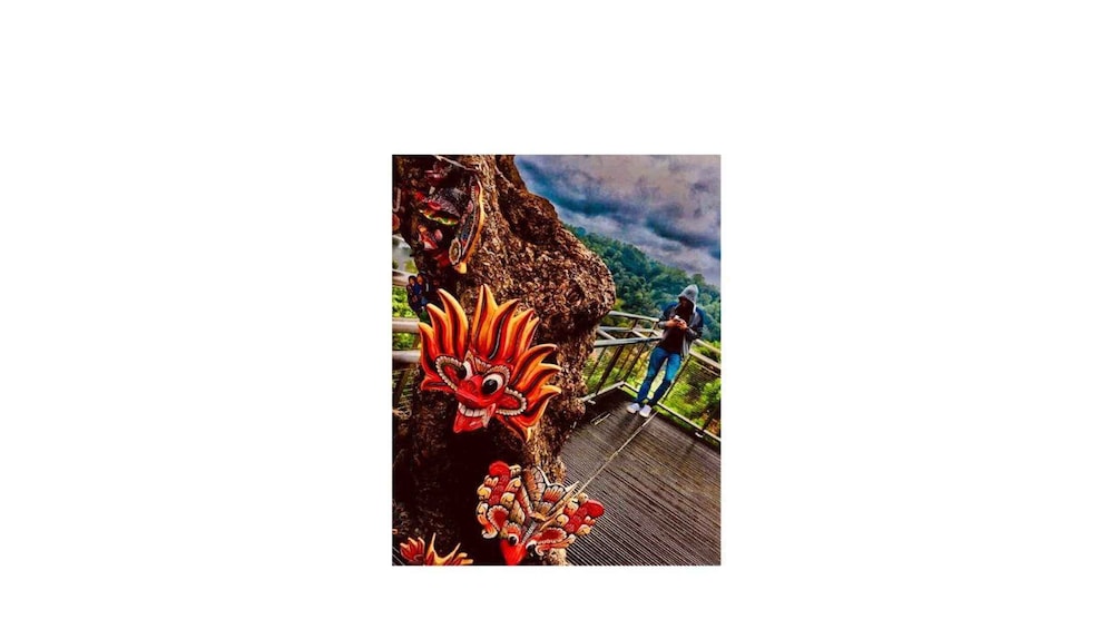 A person standing on a wooden platform with a dragon sculpture. 5