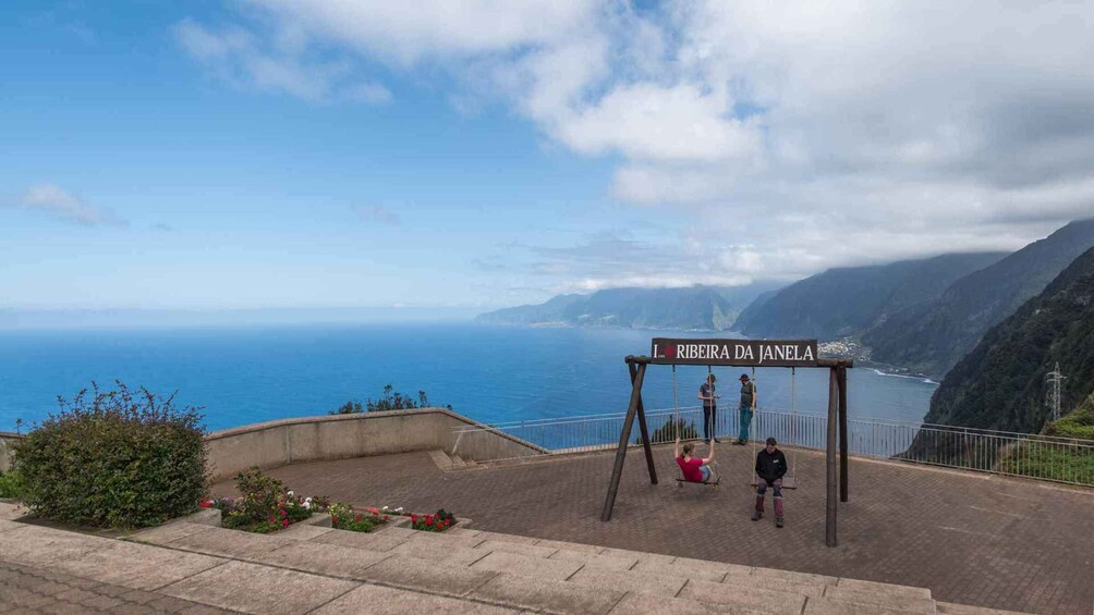 A scenic overlook with a swing set and a sign reading "RIBEIRA DA JANELA". 4