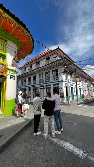 Una calle con edificios coloridos y gente parada en la acera. 1