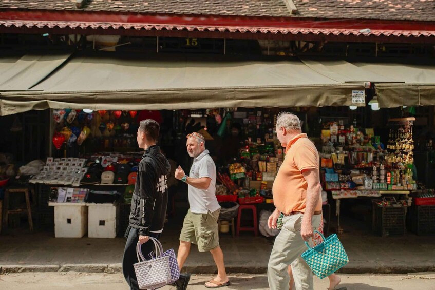 A street market with people walking past stalls selling various goods. 5