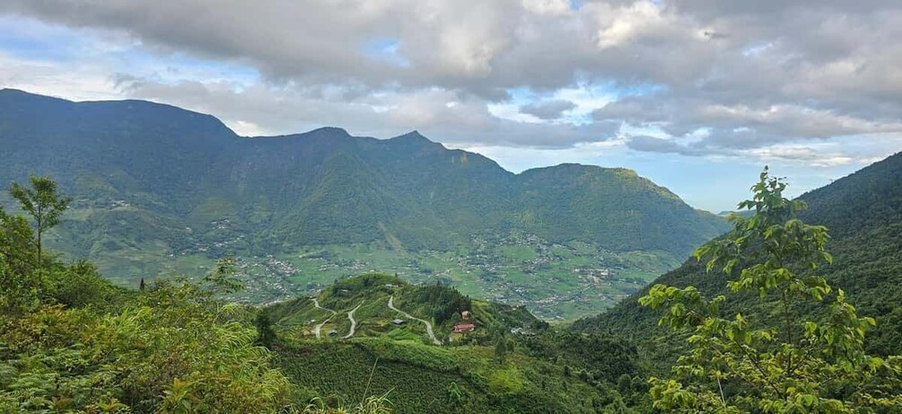 A mountainous landscape with a winding road and a small settlement. 2