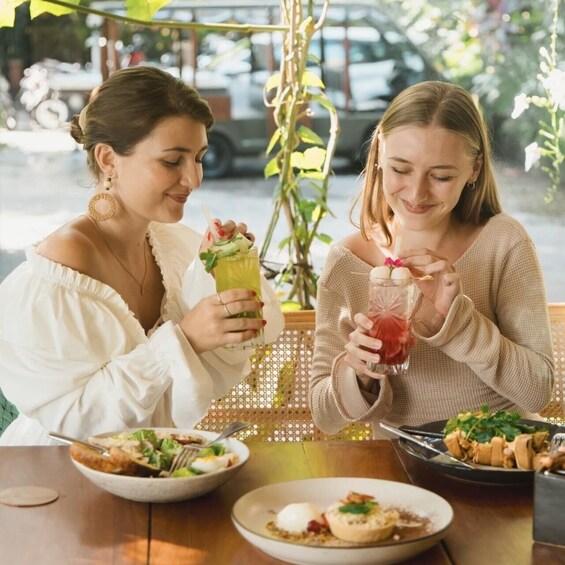 Two people sitting at a table with food and drinks. 4