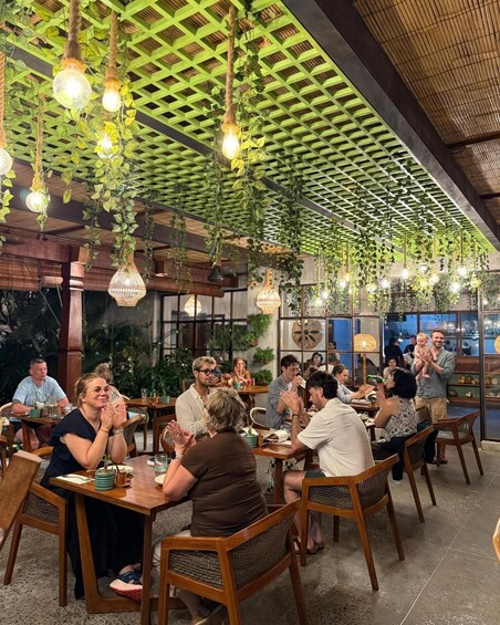 A restaurant with hanging plants and light bulbs. 5