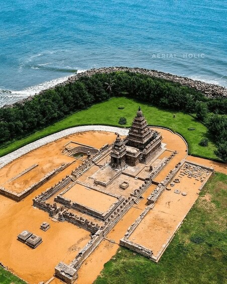 An aerial view of a temple complex with a central stupa, surrounded by a moat and a stone wall. 3