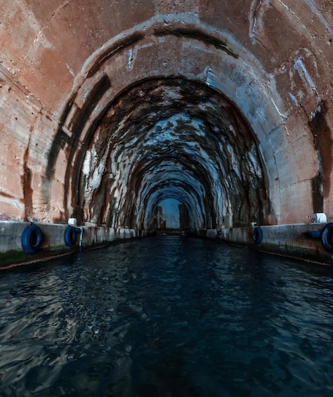 A tunnel with arched ceilings and water flowing through it. 4
