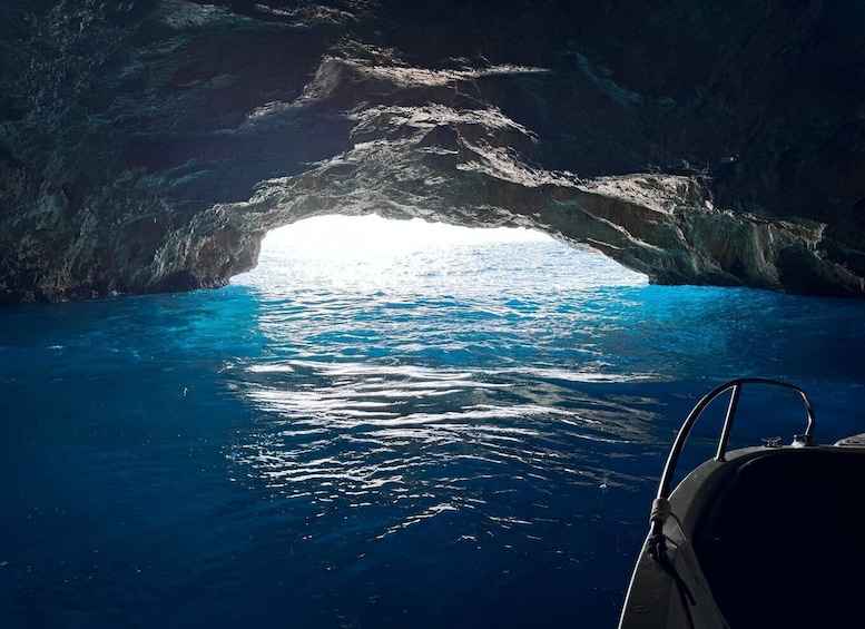 A boat in a cave with a view of the ocean. 2