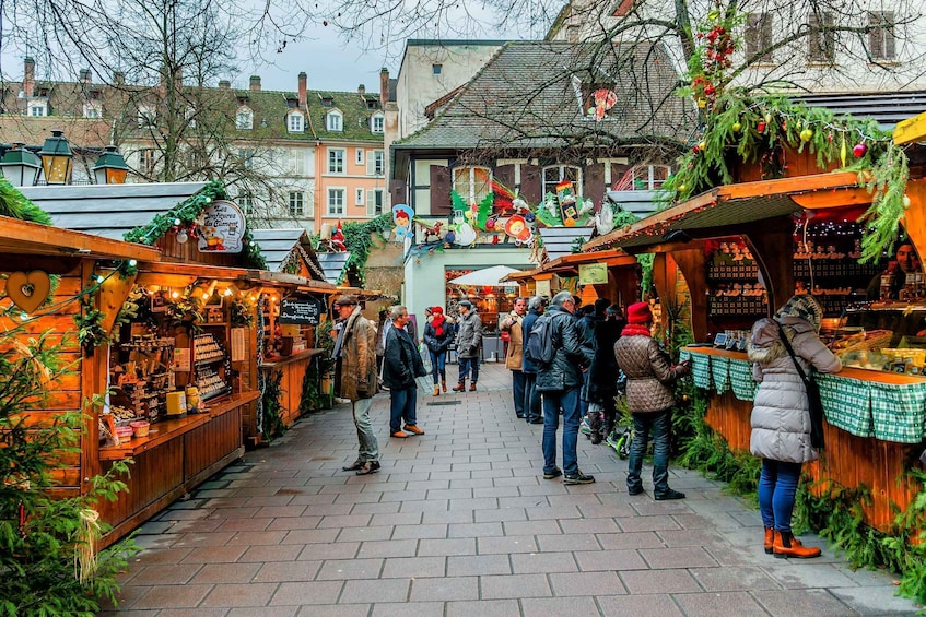 A bustling Christmas market with wooden stalls and festive decorations. 2