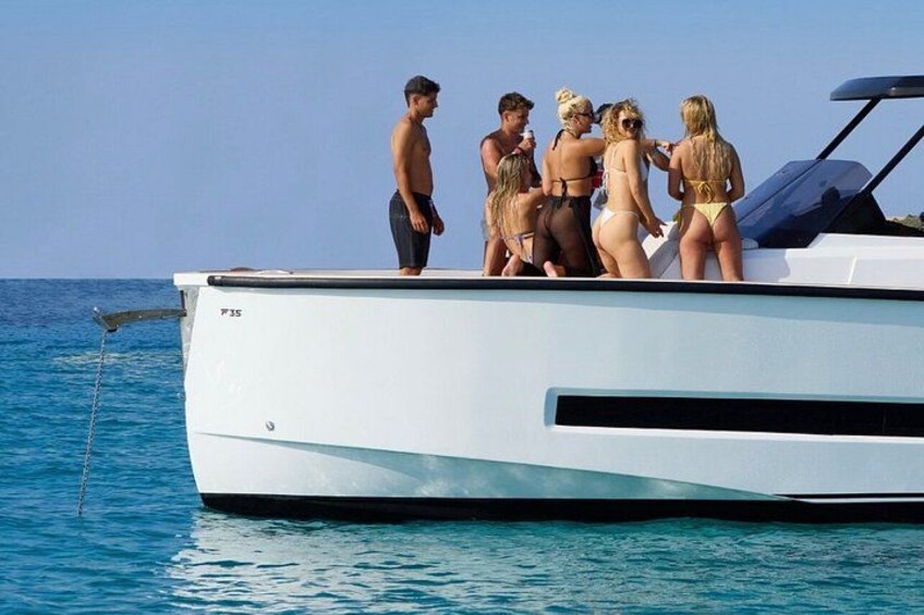 Un grupo de personas en un barco bajo un cielo azul despejado y un mar tranquilo. 5