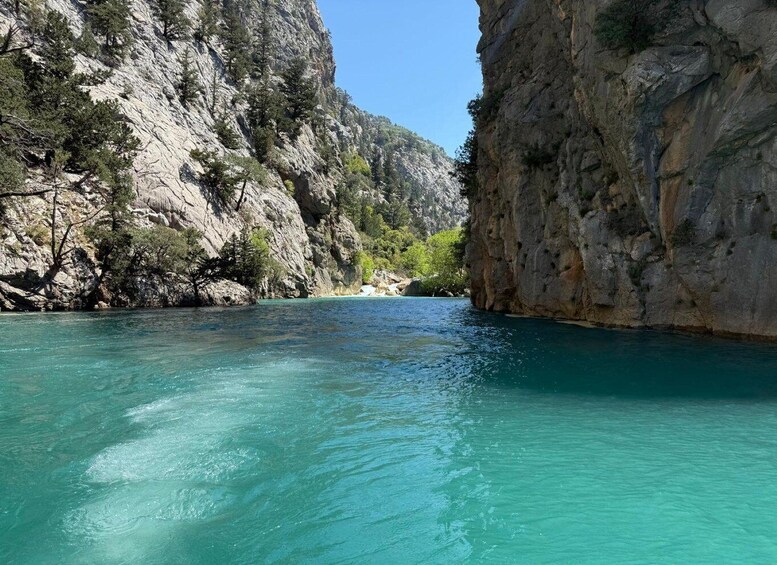 A clear turquoise sea with rocky cliffs and sparse vegetation. 3