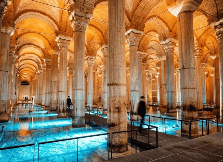 A historical building with large columns and a pool area. 2