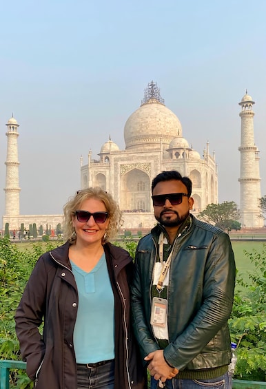 Two people standing in front of the Taj Mahal. 5