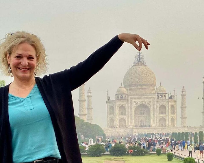 A person with a raised arm in front of the Taj Mahal. 2