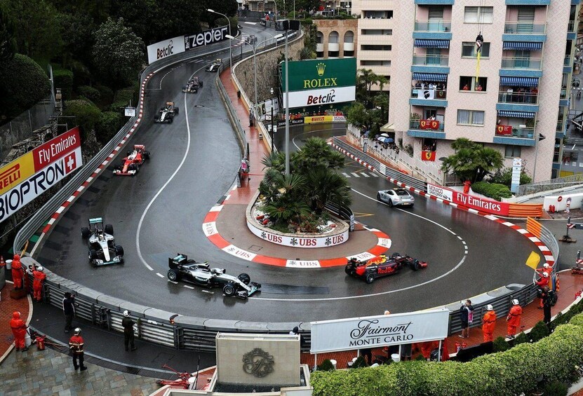 A Formula 1 race track with multiple cars, a central island with 'ROLEX Betclic' signage, and surrounding buildings. 4