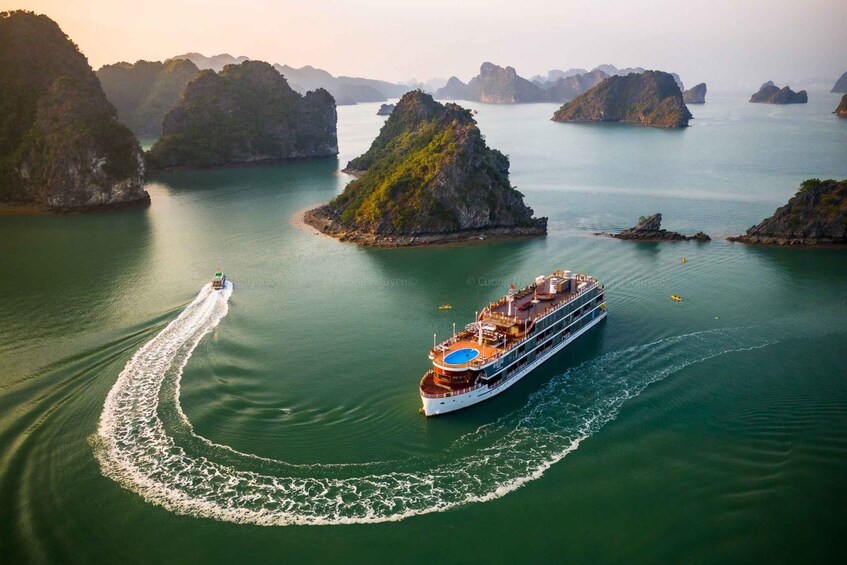 A cruise ship navigating through a calm bay with several islands. 5