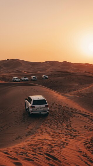 A desert landscape with a white SUV driving on a sandy road. 4