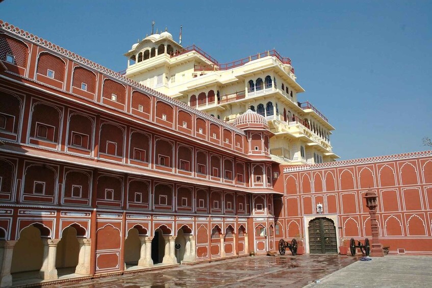 Un magnifique palais aux motifs complexes rouge et blanc, doté de nombreux balcons et d’une grande porte centrale. 2
