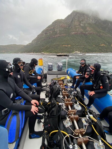 A group of scuba divers on a boat preparing for a dive. 4