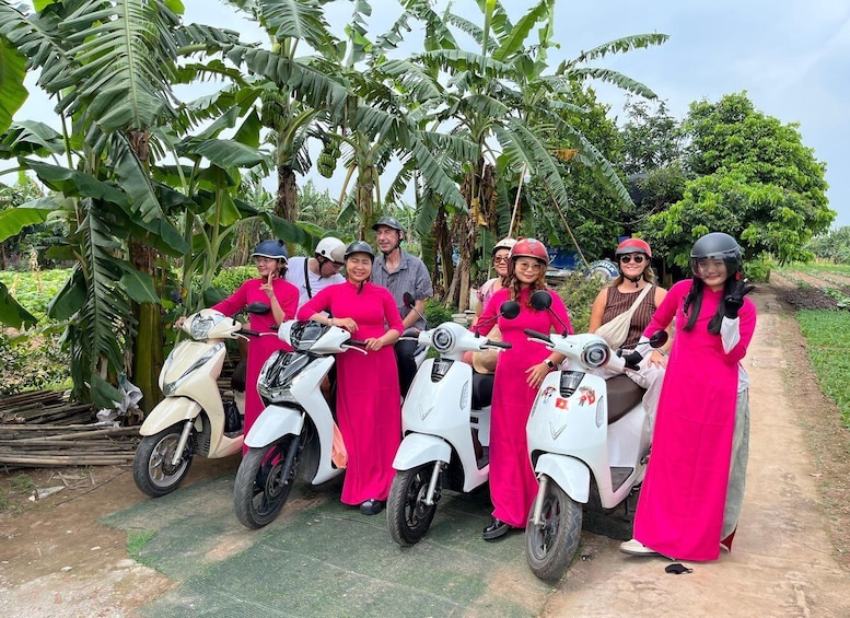 A group of people on scooters, surrounded by banana trees and greenery. 1