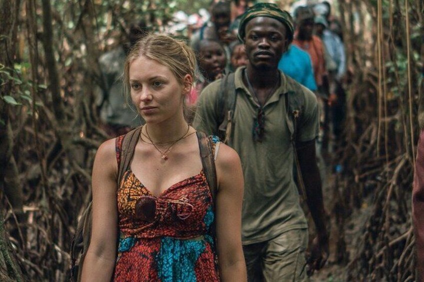 A person in a colorful dress walking through a dense forest. 4