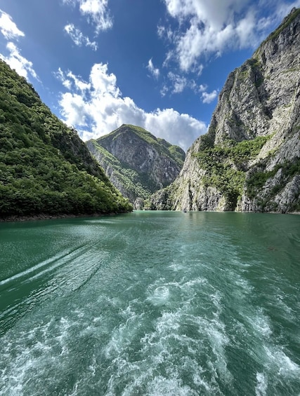 A river surrounded by steep, rocky cliffs with lush greenery. 4