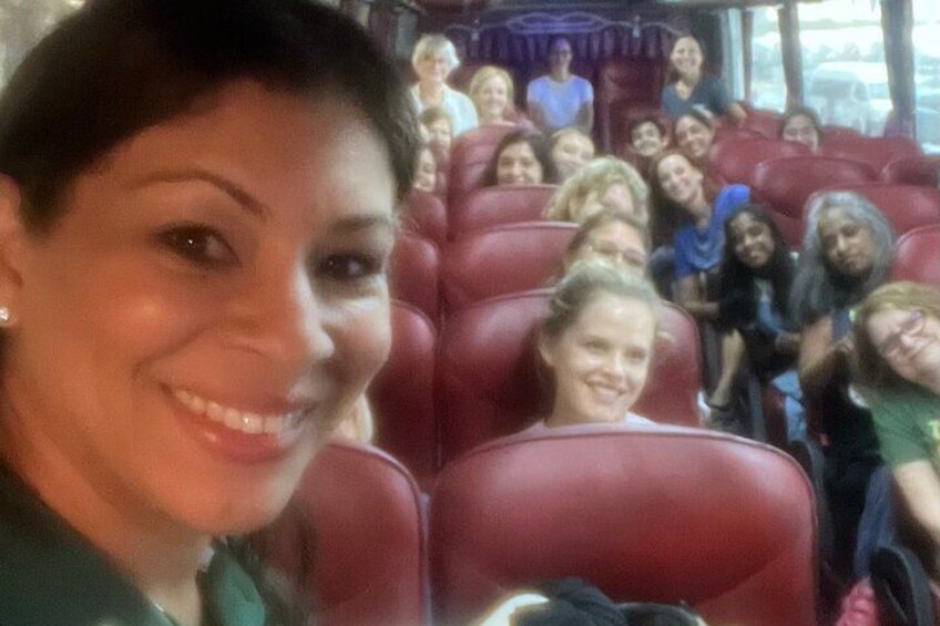 A group of people seated in red chairs, likely on a bus or in a theater. 2