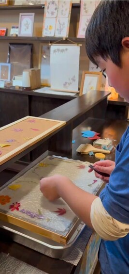 A person working on a craft project with colorful paper cutouts on a table. 2