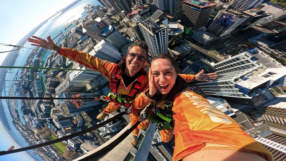 Dos personas haciendo bungee jumping con un paisaje urbano de fondo. 5