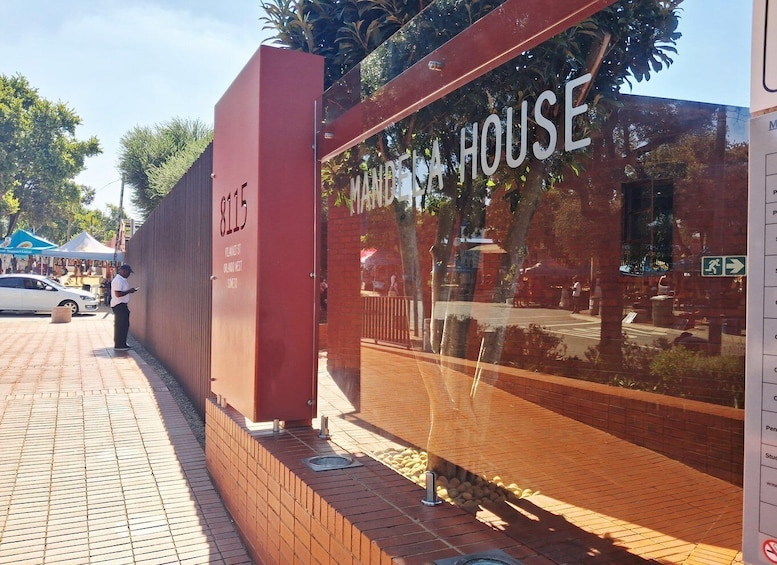 A building with a reflective glass facade and the words 'MALL HOUSE' on it. 2