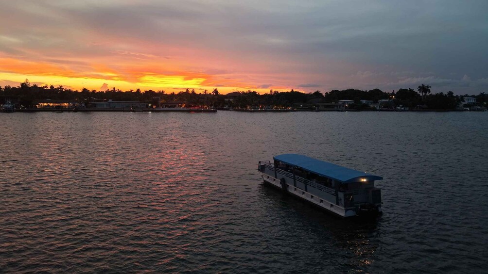A sunset over a calm body of water with a boat in the foreground. 1