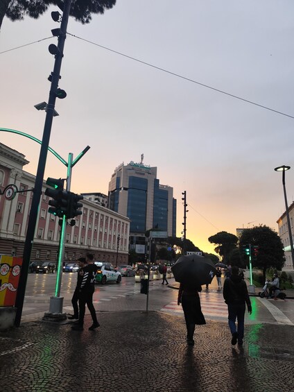 A city intersection with traffic lights, pedestrians, and a building with a 'Cofinsbank' sign. 2