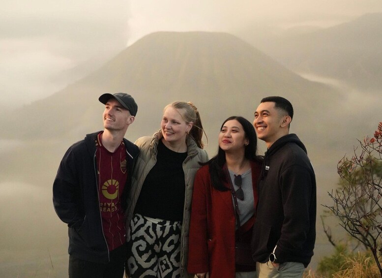 A group of people standing together with a mountain in the background. 1
