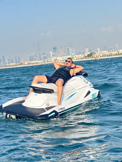 A person on a jet ski with a city skyline in the background. 1