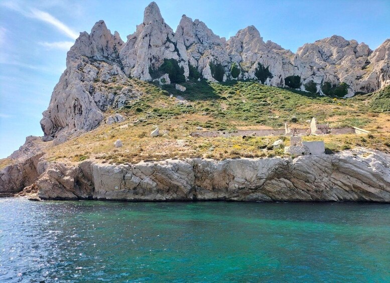A rocky coastline with clear turquoise waters and a rugged mountain backdrop. 3